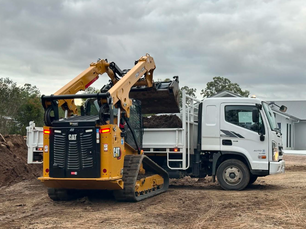 CAT skid steer loading soil into Minespec tipper truck — Brisbane